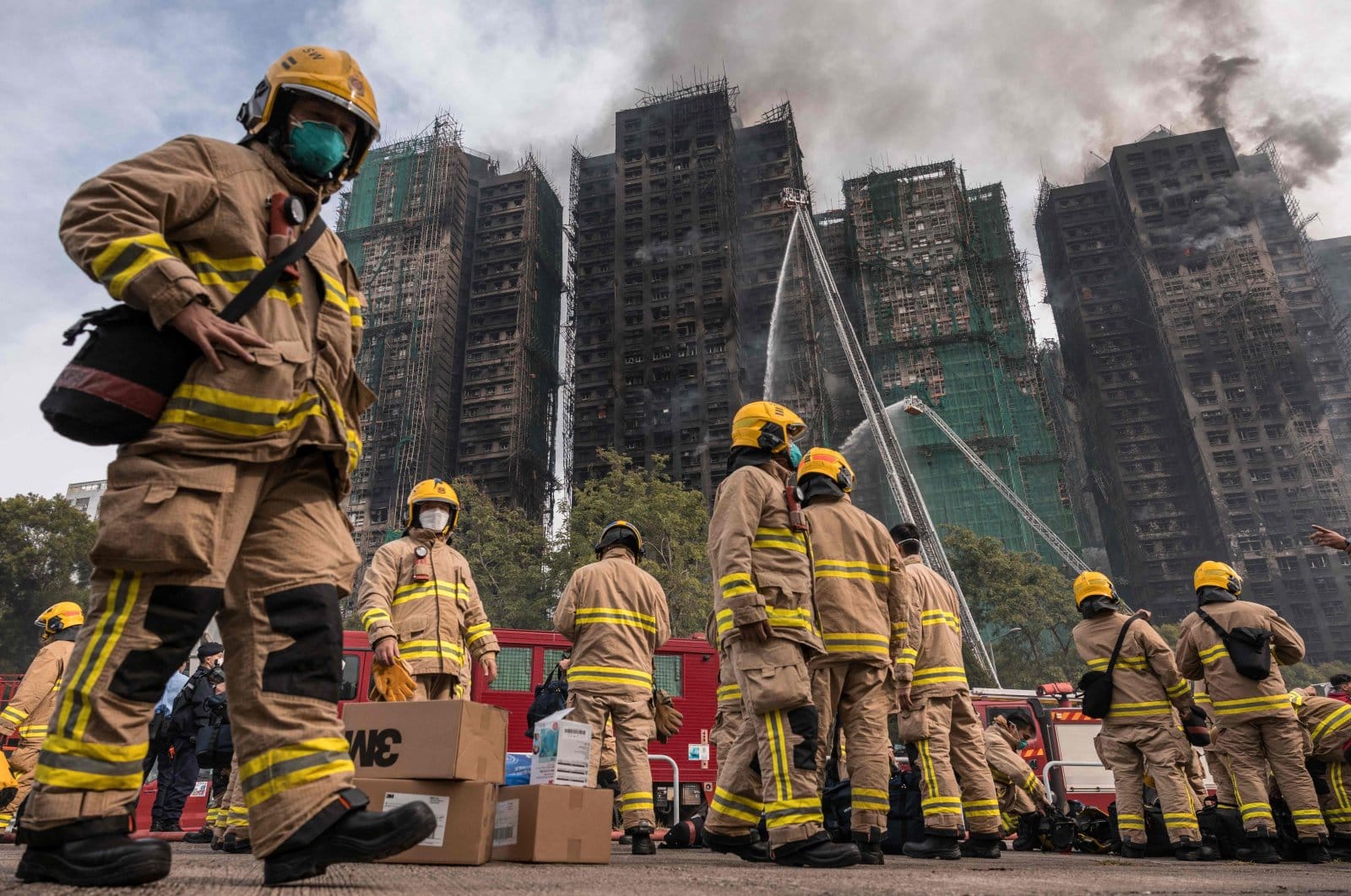 Firefighters prepare as a major fire sweeps through multiple apartment blocks at the Wang Fuk Court residential estate in Tai Po.