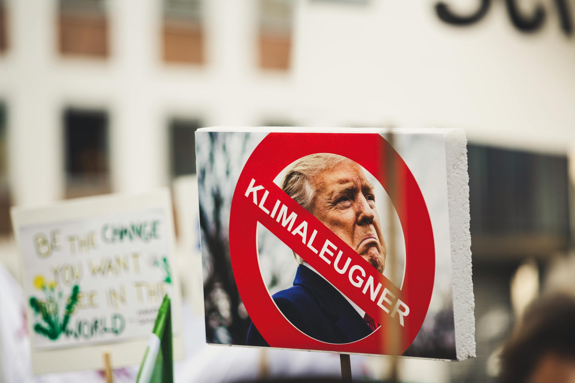 Protestors holding a placard bearing a picture of the US President Donald Trump