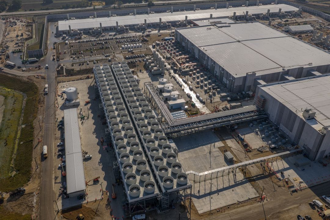 A large data center facility, representing the massive physical infrastructure and AI spending driving tech companies to realign their workforces.