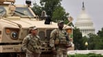 National Guardsman leaning on a armoured vehicle with the congress building in the background