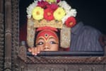 Wearing an elaborate headdress and painted eyes, Kumari Devi.